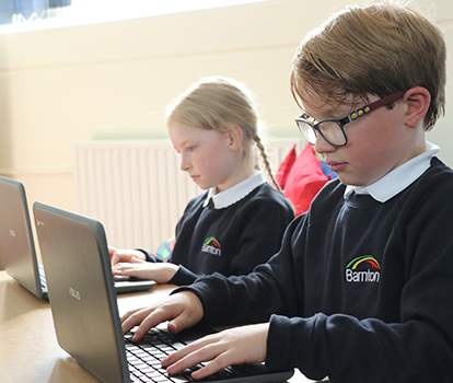 2 pupils working on a laptop together